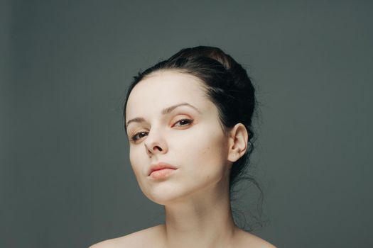 portrait of a beautiful brunette woman with bare shoulders fashionable hairstyle model. High quality photo