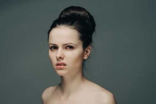 beautiful brunette with bare shoulders on gray background cropped view. High quality photo
