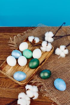 easter eggs on chalkboard and white flowers in burlap blue background. High quality photo