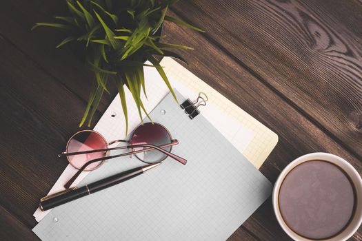 notepad for notes on the table and glasses pen office flower potted coffee cup. High quality photo