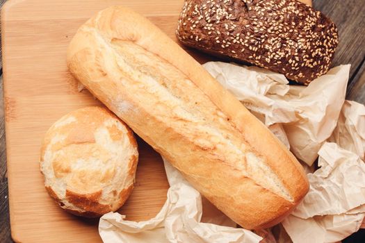 flour products loaf of bread and wood board light background. High quality photo