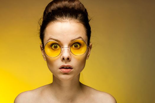 brunette with yellow glasses bare shoulders clear skin. High quality photo