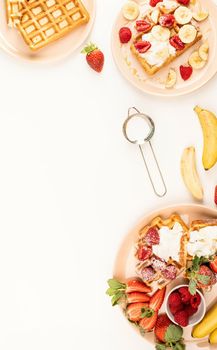 Homemade waffles with fruits and berries, cream and honey in a plate on white table. Flat lay, top view, copy space.