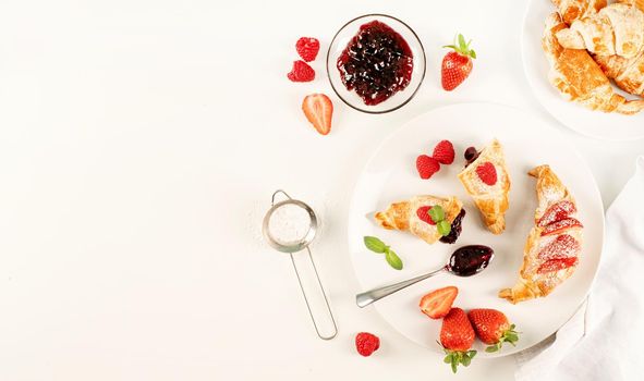 delicious golden croissants filled with strawberry jam. Flat lay, top view, copy space.