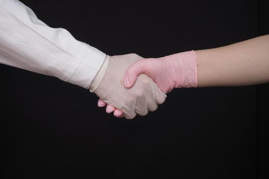 Personal protective equipment. Medical gloves. Two hands in medical gloves, a handshake. High quality photo