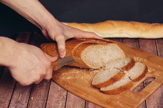 cutting a fresh loaf on a cutting board crispy bread kitchen meal. High quality photo