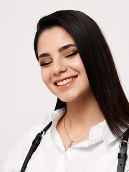happy brunette in white shirt with black suspenders and makeup portrait close-up. High quality photo