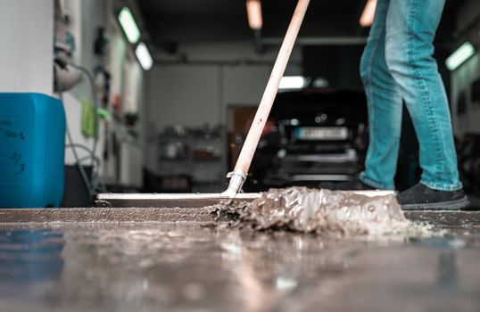 Clean the floor at the car wash with the help of a water spatula.