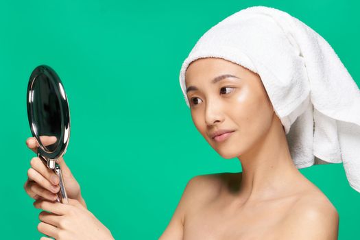 woman asian appearance grandfather pipe sweat face clean skin mirror in hands close up. High quality photo