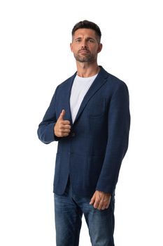 Portrait of handsome mid adult serious business man dresses in jeans and blue blazer posing with thumb up isolated on white background