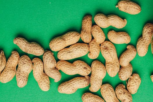 peanuts in shells snack Green background snack for alcohol. High quality photo
