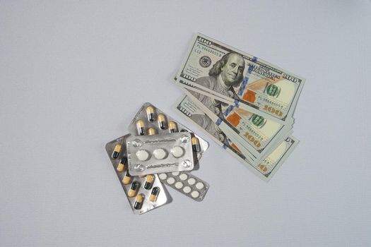 Banknotes, the US dollar, and medicines. The concept of the cost of medicines. High quality photo