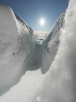 Ice slopes in sunny winter day, transparent ice of blue color, purely blue sky, long shadows, a pure snow-covered virgin soil, snow barkhans, . High quality photo