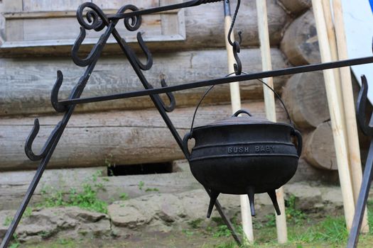 Hiking kitchen, cast-iron pot on the stand. Cooking at the stake.