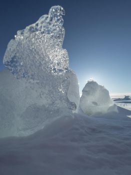 Ice slopes in sunny winter day, transparent ice of blue color, purely blue sky, long shadows, a pure snow-covered virgin soil, snow barkhans, . High quality photo