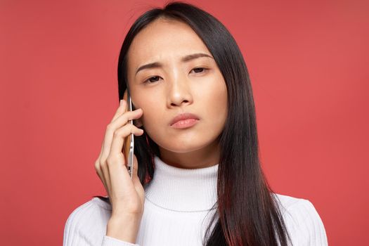 pretty asian woman talking on the phone technology red background. High quality photo