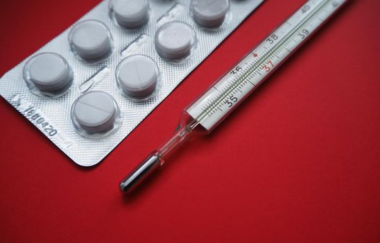 Tablets blister packing and a close-up thermometer, an image in the corner.