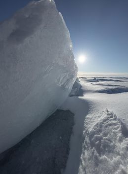 Ice slopes in sunny winter day, transparent ice of blue color, purely blue sky, long shadows, a pure snow-covered virgin soil, snow barkhans, . High quality photo