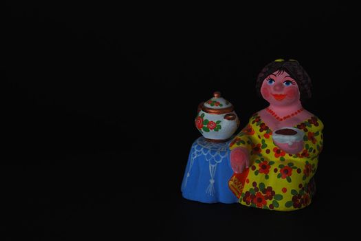 Ceramic figurines. A woman with a kettle, a samovar. Tea party. Close-up.