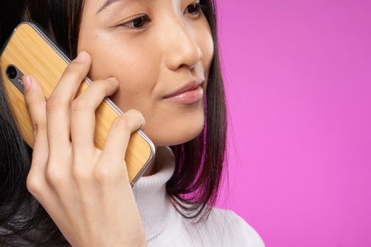 pretty asian woman talking on the phone technology close-up. High quality photo