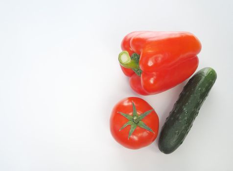 Fresh vegetables. Red tomato, bell pepper, and cucumber. Big plan on a white background.