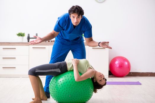 Fitness instructor helping sportsman during exercise