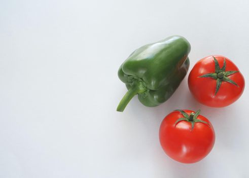 Fresh vegetables. Red tomato, bell pepper, and cucumber. Big plan on a white background.