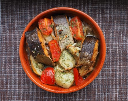 A dish of fish with vegetables baked in the oven. Close-up.