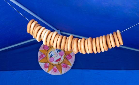 Lots of bagels on a string on a blue background.Healthy food concept, Easter, Maslenitsa.