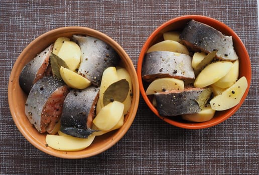 The dish of fish with vegetables is raw. Close-up.