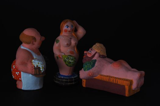 Funny figurines of plaster, clay and ceramics. Bath. The people in the steam room. It's a macro- Black background.