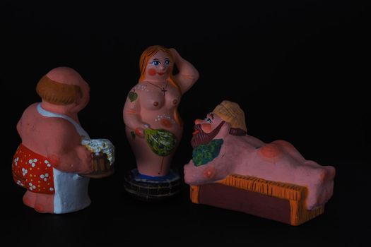 Funny figurines of plaster, clay and ceramics. Bath. The people in the steam room. It's a macro- Black background.