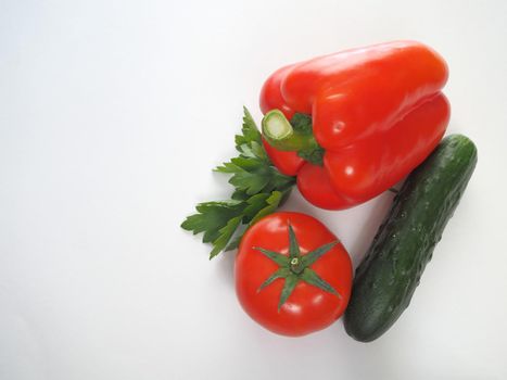 Fresh vegetables. Red tomato, bell pepper, and cucumber. Big plan on a white background.