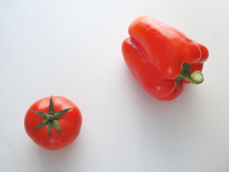 Fresh vegetables. Red tomato and bell pepper sweet. Close-up on a white background.