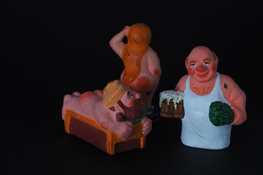 Funny figurines of plaster, clay and ceramics. Bath. The people in the steam room. It's a macro- Black background.