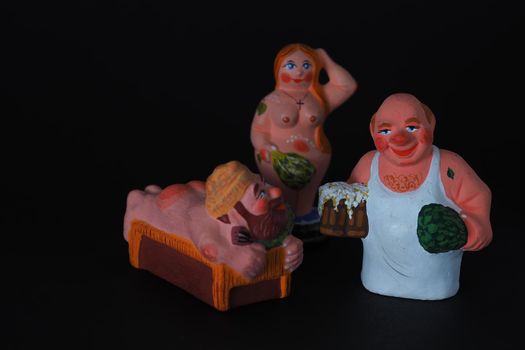 Funny figurines of plaster, clay and ceramics. Bath. The people in the steam room. It's a macro- Black background.