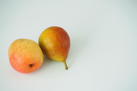 Ripe fruit. Two beautiful pears on a white background in the left corner.