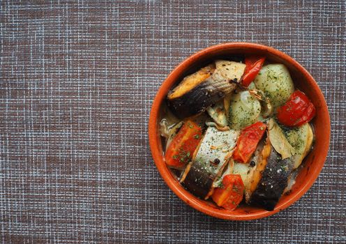 A dish of fish with vegetables baked in the oven. Close-up.