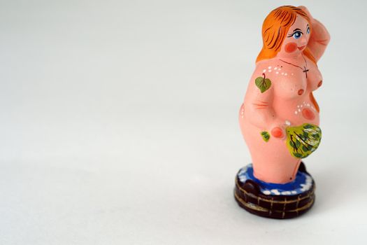 Funny figurines made of clay or plaster ceramics. Souvenir woman in the bath with a broom.
