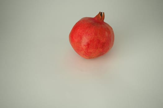 Fruits. Ripe red pomegranate. Whole fruit on a white background.