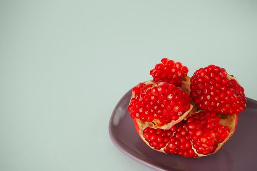 Ripe pomegranate. Red fruit with ripe grains. Isolated on a white background.