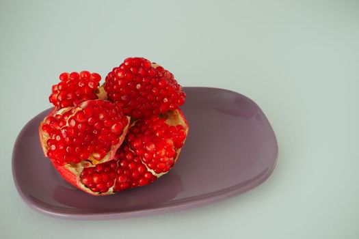 Ripe pomegranate. Red fruit with ripe grains. Isolated on a white background.