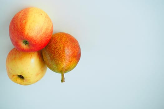 Ripe fruit. Two pears and an apple on a white background. Horizontal image. 