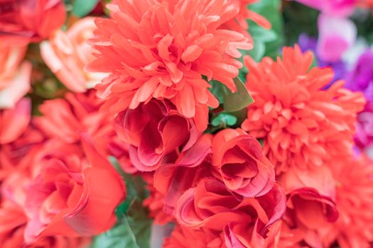 artificial multicolored flowers close up as background. High quality photo