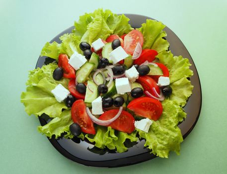 Greek fresh vegetable salad with feta cheese and olive oil in a bowl. Close-up, high-quality photo.