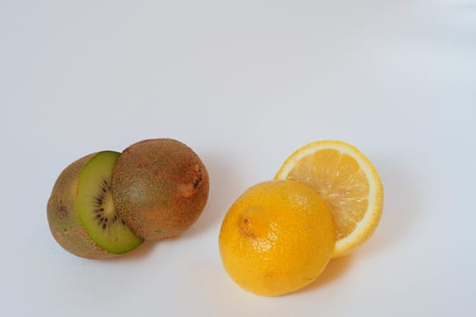 Fruits are citrus and tropical. Kiwi and lemon. Close-up, white background. High quality photo