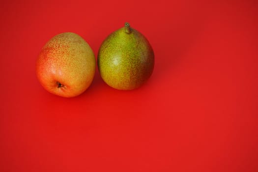 Ripe pears. Beautiful fruit on a red background. Bright image, horizontal.