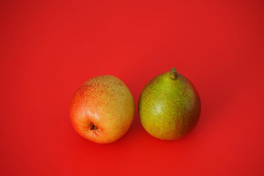 Ripe pears. Beautiful fruit on a red background. Bright image, horizontal.