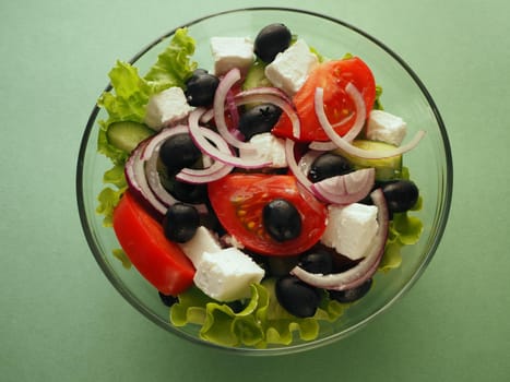 Greek fresh vegetable salad with feta cheese and olive oil in a bowl. Close-up, high-quality photo.