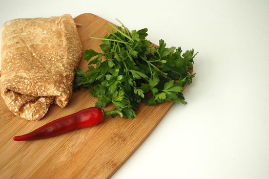 Thin Armenian pita bread with tomatoes greens and spices. ingredients for homemade vegetarian falafel.